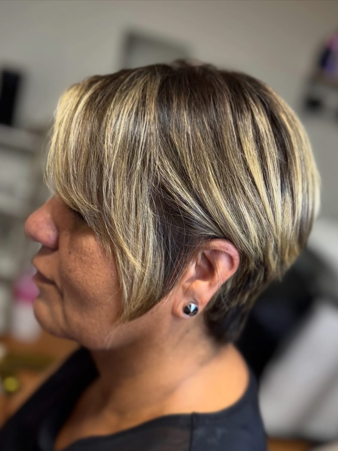 Short layered haircut with blonde highlights at Space Bela Salon